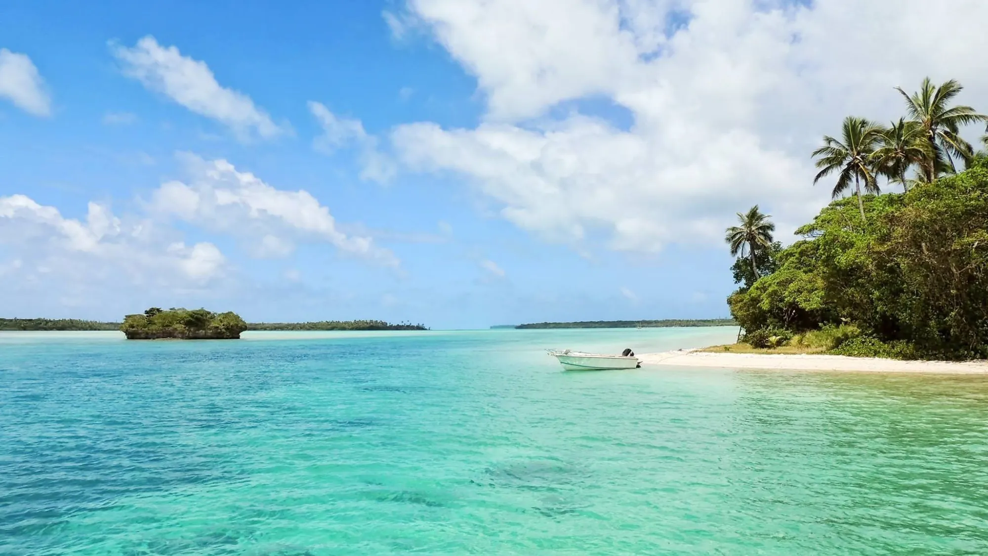 Turquoise shallows and white sand under a bright Boracay sky