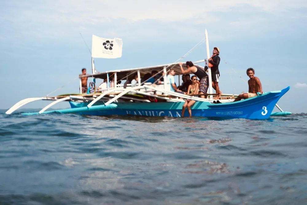 Happiness guests on a bangka over turquoise water on an island hopping day