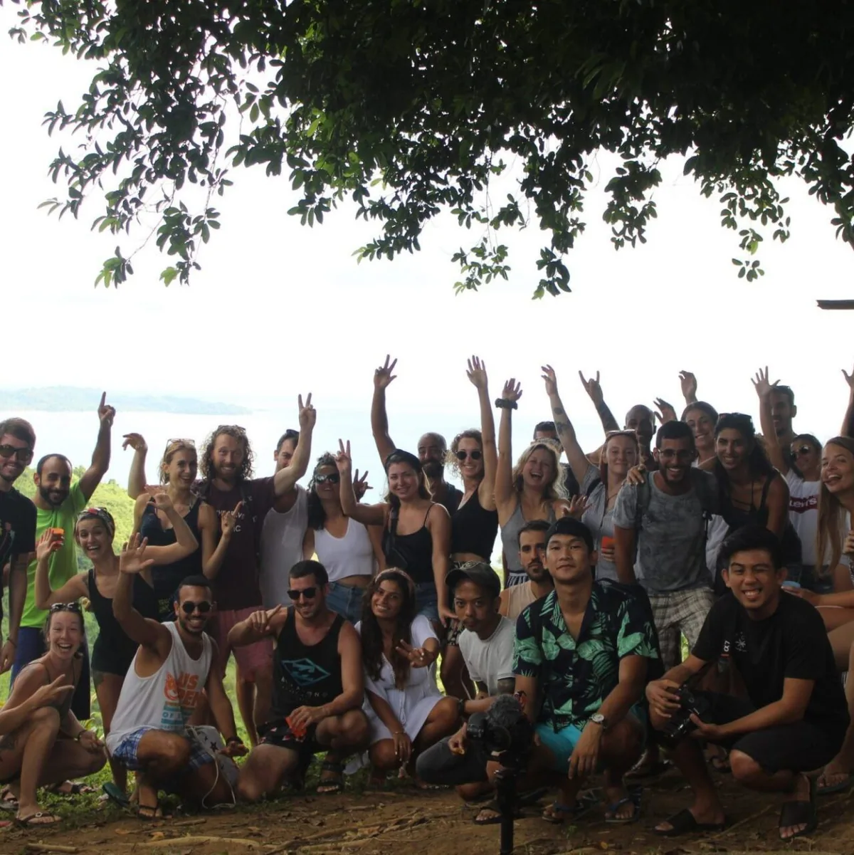 A big group of guests cheering under the trees on a tour day