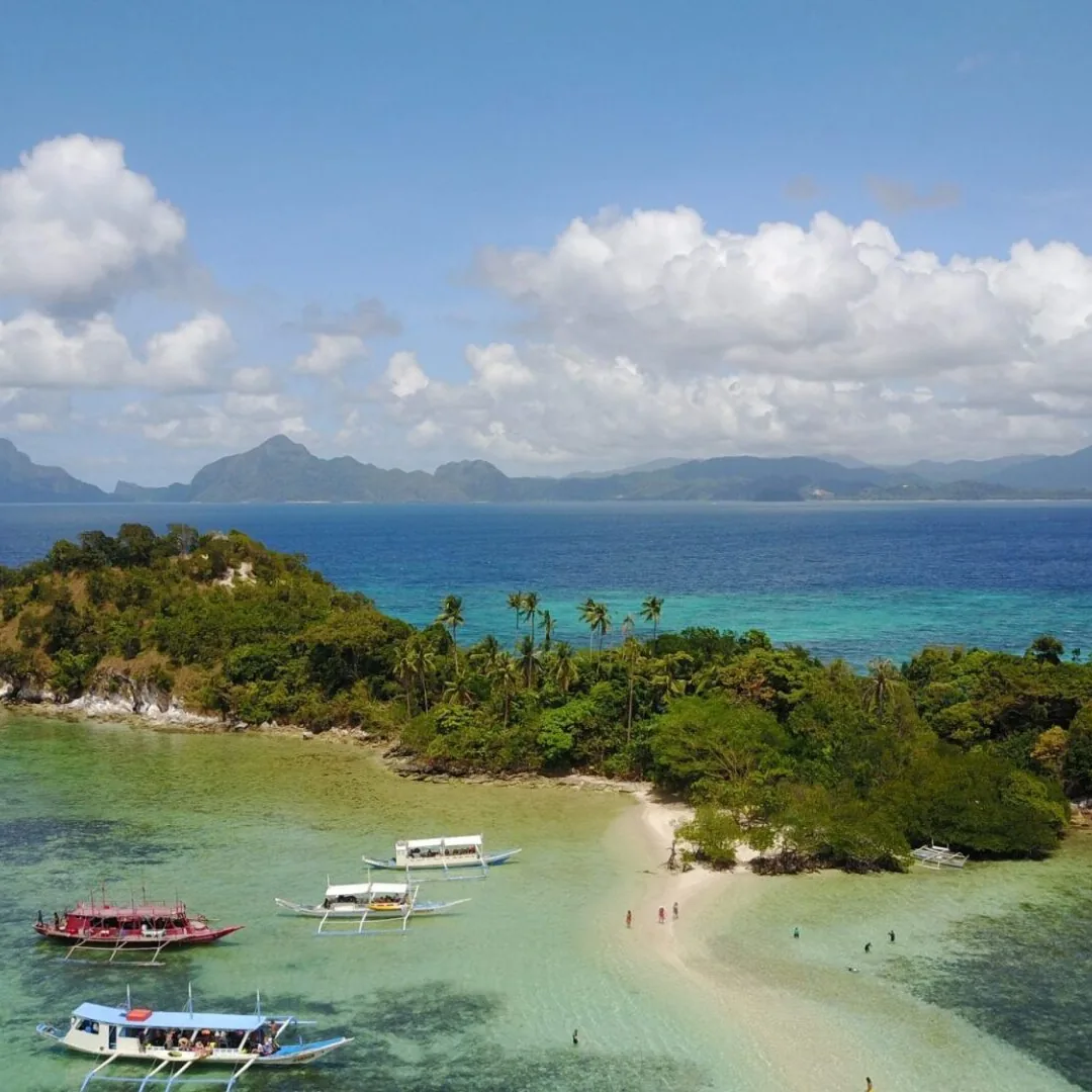 Boats at an island sandbar on turquoise water