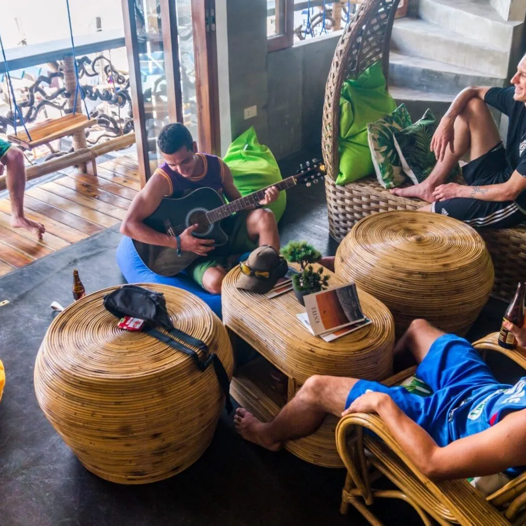 Friends lounging on rattan chairs on a breezy terrace