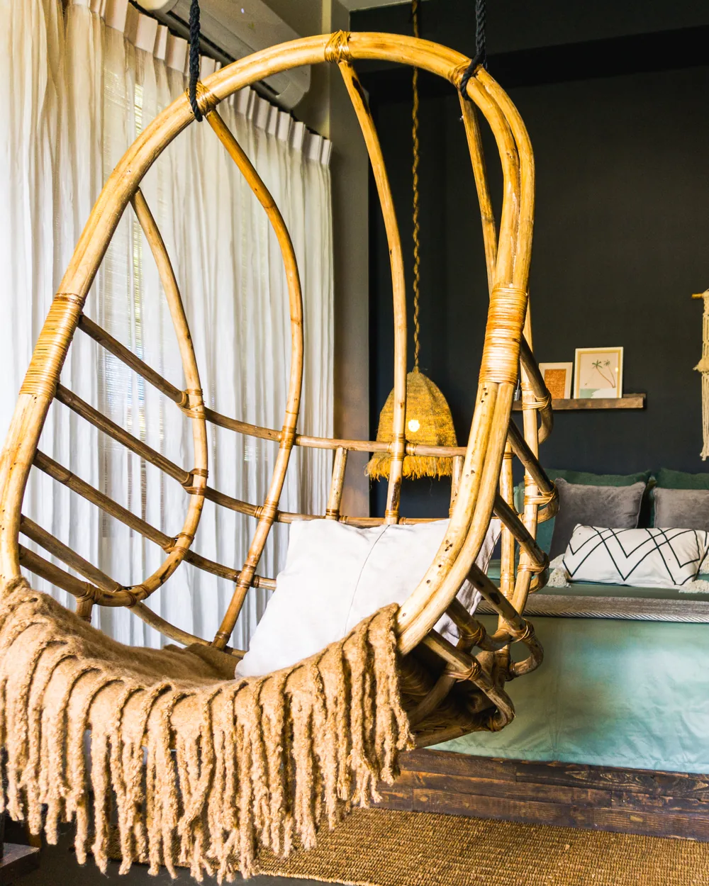 A styled suite with a rattan hanging chair at Happiness El Nido