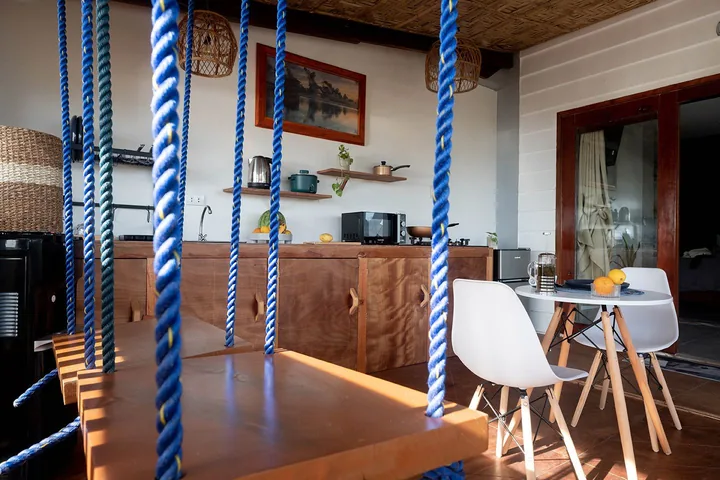 Lounge with wooden swings overlooking the sea at Happiness Hostel El Nido