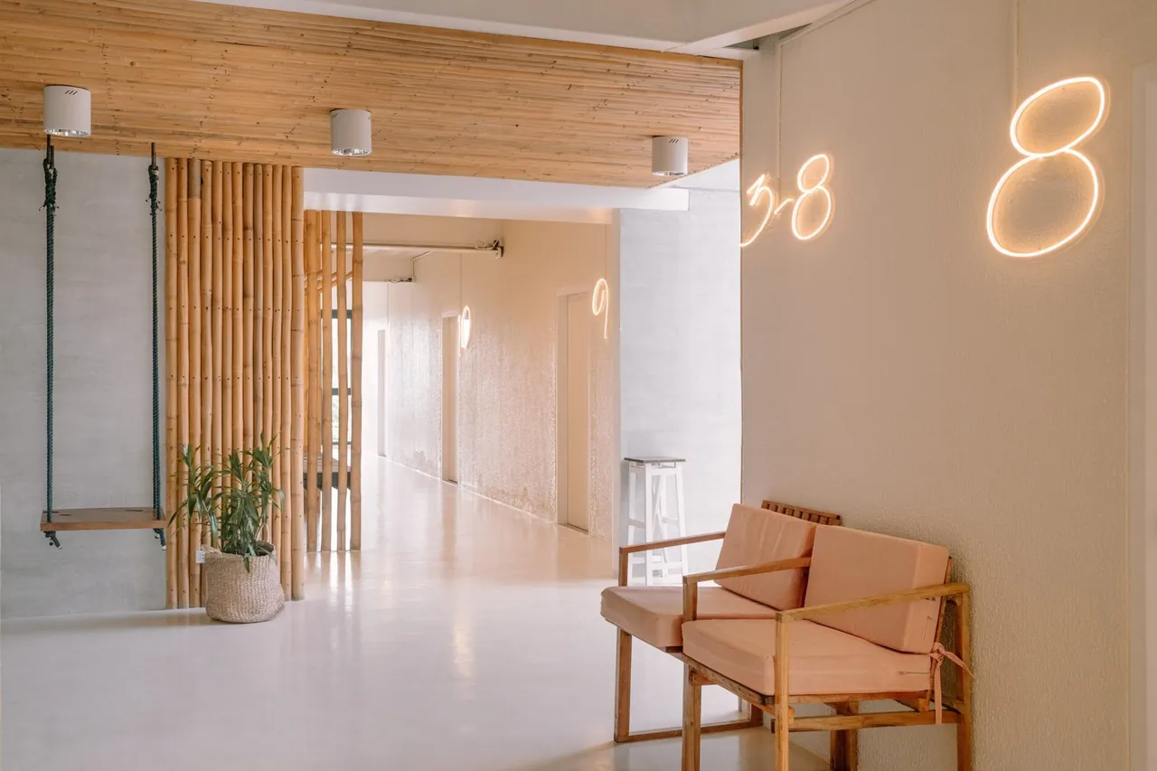 A bright bohemian hostel room with wood and rattan details
