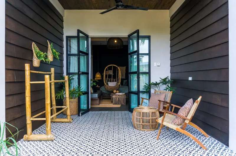 The tiled entrance of a boutique villa framed by tropical plants