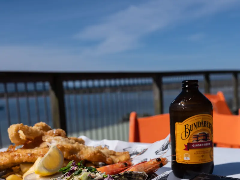 A beachside dinner of fried seafood with a cold drink overlooking the sea