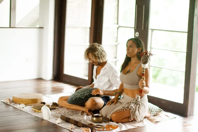 A practitioner guiding a seated guest through bodywork
