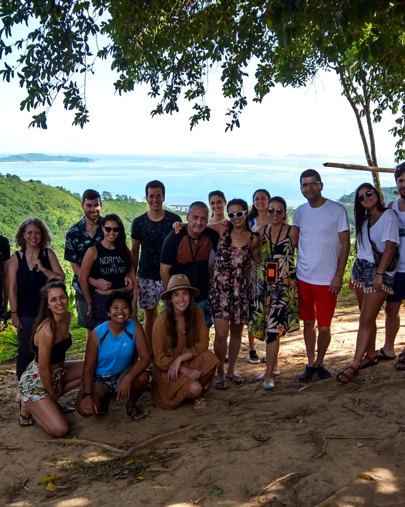 A big Happiness group together on the beach under the trees