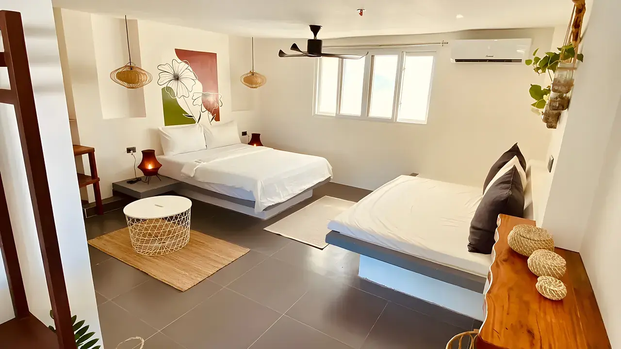 A bright private room with a fan and a soft double bed