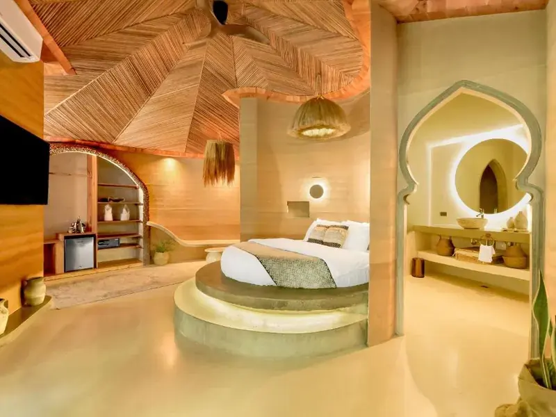 The king suite with a round bed under a sculpted ceiling