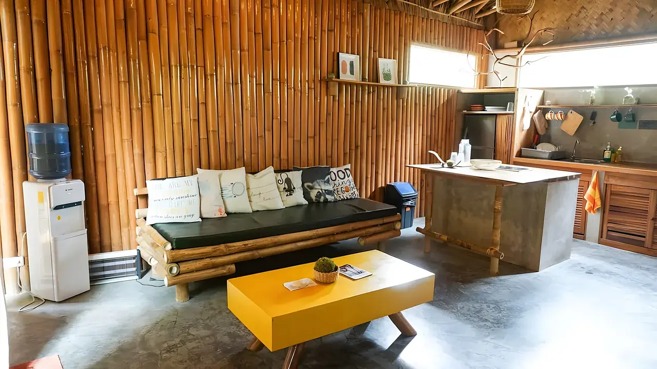 A villa lounge with a long daybed and a bright yellow coffee table