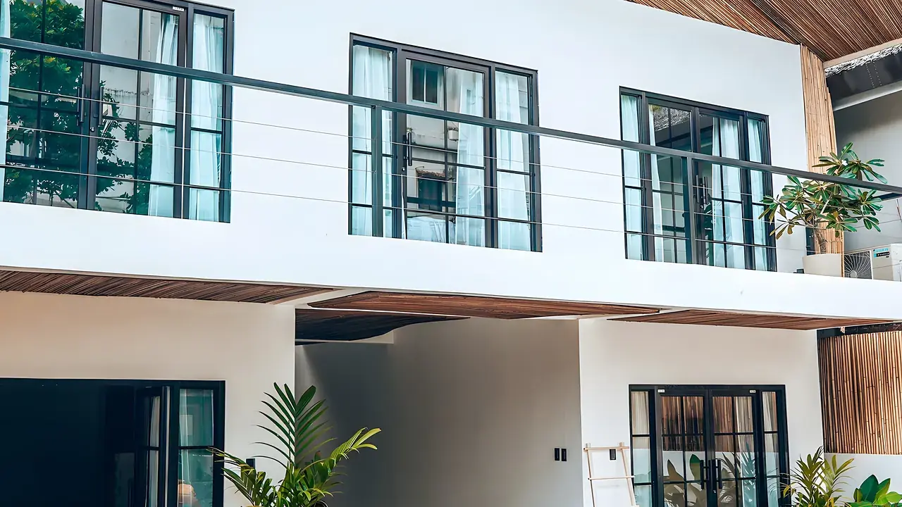 A private villa with a turquoise pool and wooden decks among tropical plants