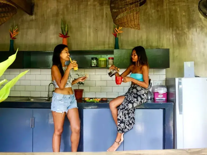Two friends cooking together in a bright villa kitchen