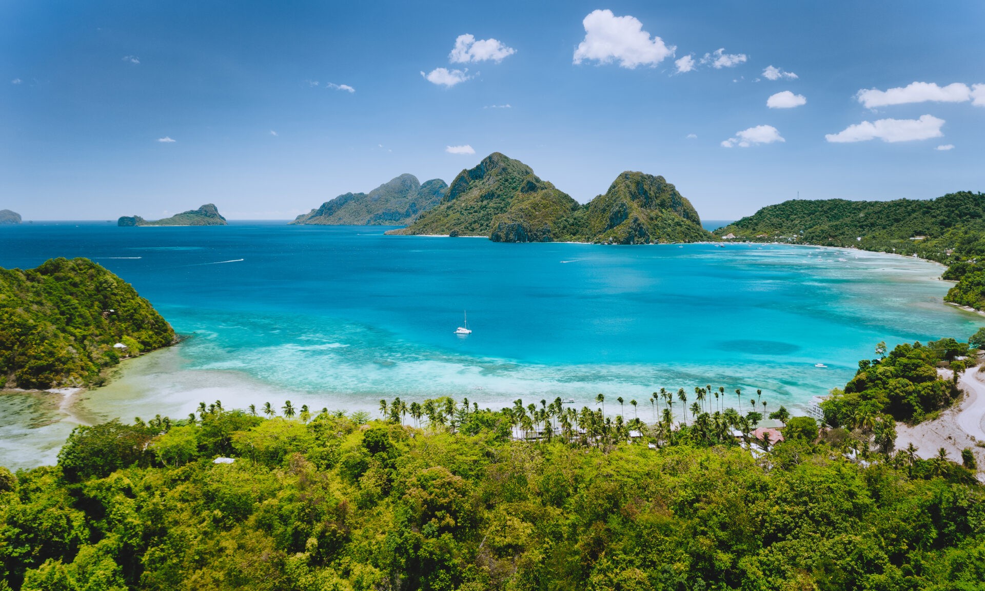 Aerial drone panoramic view of Las Cabanas beach and exotic ocean shallow lagoon in El Nido, Palawan, Philippines